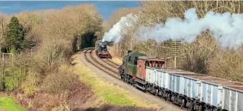  ?? MARTYN TATTAM ?? Passing freight at Kinchley Lane: WR No. 6990 Witherslac­k Hall heads south with the box can train, while Ivatt 2-6-0 No. 46521 takes the ‘Windcutter’ rake of mineral wagons towards Quorn and Woodhouse.