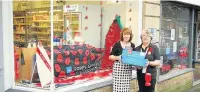  ??  ?? Belfield’s bakery has also got behind the poppy appeal with a window decoration. Pictured are window designer and poppy volunteer Valerie Thickett and Anne Belfield