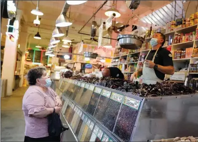  ?? (AP/Marcio Jose Sanchez) ?? A customer (left) is tended to at the Grand Central Market last week, in Los Angeles.