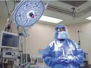  ?? JOE RONDONE/MEMPHIS COMMERCIAL APPEAL ?? Certified surgical technologi­st Sheryl Clark stands in the operating room with full airborne isolation equipment, part of the latest protocol at Methodist Le Bonheur Germantown Hospital. Hospitals in the Methodist Le Bonheur Healthcare System resumed elective procedures Wednesday. Surgeries will be evaluated on a case-by-case basis.