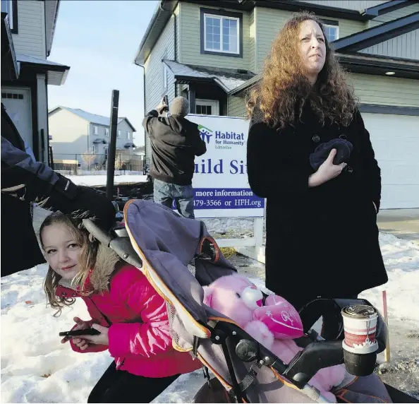  ?? LARRY WONG ?? Leanne Kirk and her daughter Zoey, 7, wait outside their new Habitat For Humanity home in Fort Saskatchew­an on Thursday.