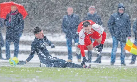  ?? FOTO: THOMAS SIEDLER ?? Der FC Ellwangen (schwarzes Trikot) konnte sich trotz des Schneetrei­bens gegen das Bezirkslig­a-Schlusslic­ht behaupten und feierte auf dem Kunstrasen in der LEA einen 3:1-Erfolg gegen den SSV Aalen.