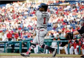  ?? PATRICK MCDERMOTT / GETTY IMAGES ?? The Braves’ Ozzie Albies hits a double, scoring Ronald Acuna, in the first inning against the Nationals on Friday in Washington. Acuna had led off the game with a single, then stole second before being knocked home.