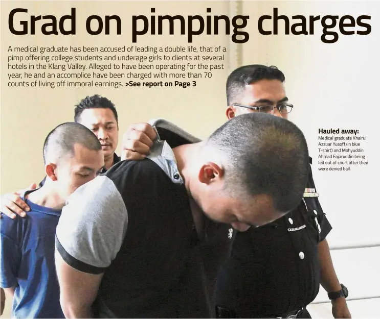  ??  ?? Hauled away: Medical graduate Khairul Azzuar Yusoff (in blue T-shirt) and Mohyuddin Ahmad Fajaruddin being led out of court after they were denied bail.