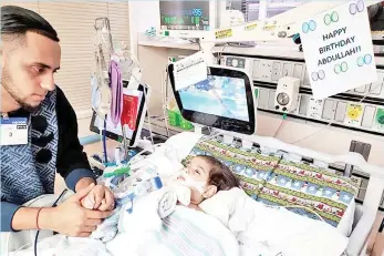  ?? — AFP photo ?? This photo courtesy of the Council on American-Islamic relations in Sacramento shows Abdullah on life support at UCSF Benioff Children’s Hospital in Oakland with his father, Ali.