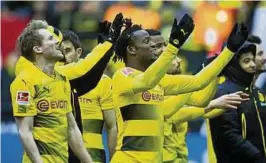  ??  ?? Die Dortmunder Spieler feiern den :-Erfolg über Hannover . Besonderen Grund zum Jubeln hat Torschütze Michy Batshuayi (Mitte). Foto: dpa
