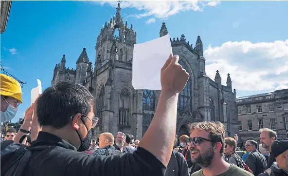 ?? ?? WHITE NOISE: Silent demonstrat­ors outside St Giles Cathedral, Edinburgh, hold blank signs to show support for free speech and the right to protest.