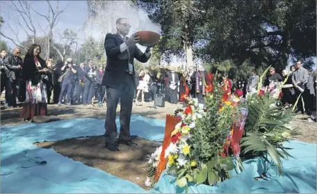  ?? Francine Orr Los Angeles Times ?? CHAPLAIN Manuel Torres, holding incense, helps to honor the unclaimed dead in Los Angeles on Wednesday. This year, more than 900 of those whose cremated remains were buried in a mass grave were men, about 400 were women, and more than 120 were babies.