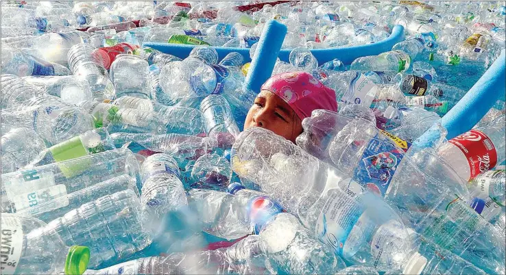  ?? ROMEO GACAD/AFP ?? A child swims in a pool filled with plastic bottles during an awareness campaign to mark the World Oceans Day in Bangkok on Saturday.