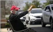  ??  ?? Monsignor James Treston waves to well-wishers as they drive by St. Catharine of Siena Catholic Church in Exeter Township on the afternoon of May 14to congratula­te him for 60years in the priesthood.