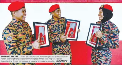  ??  ?? BURNING BRIGHT ... From left: Fazry Vincent, Ahmad Najabah Zuel and Norazizah Nordin receiving their awards after finishing top of their class in Special Tactical Operation and Rescue Team course in Marang, Terengganu yesterday. - BERNAMAPIX