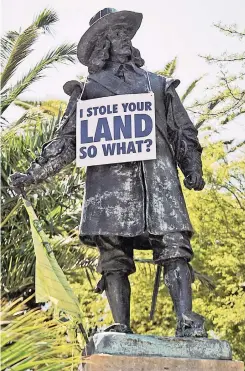  ??  ?? PLACARDS hang around the necks of the statues of Jan van Riebeeck and his wife Maria de la Quellerie in the CBD.