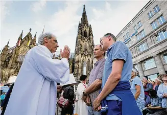  ?? Martin Meissner/Associated Press ?? Same-sex couples take part in a public blessing ceremony in front of the Cologne Cathedral in Cologne, Germany, on Sept. 20. Pope Francis has formally approved allowing priests to bless same-sex couples, with a new document released Monday.