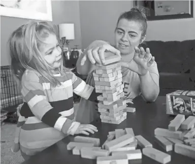  ?? SARAH KLOEPPING/USA TODAY NETWORK-WISCONSIN ?? Cheri Branham plays Jenga with her youngest daughter, 3, in their home in Howard.