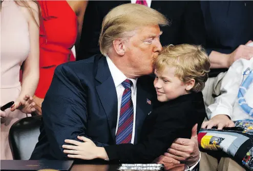  ?? EVAN VUCCI / THE ASSOCIATED PRESS ?? President Donald Trump kisses Jordan McLinn, a Duchenne Muscular Dystrophy patient, after signing the Right to Try bill in the South Court Auditorium on the White House campus in Washington on Wednesday.