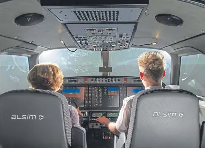  ?? Picture: Kim Cessford. ?? Caroline Strain, head of Partnershi­ps North, Scottish Enterprise, and pilot-in-training Gavin Ritchie in Tayside Aviation’s new simulator.