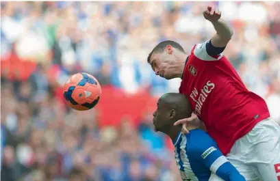  ?? AP ?? Arsenal’s Thomas Vermaelen heads the ball against Wigan Athletic. —