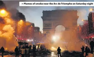 ??  ?? &gt; Plumes of smoke near the Arc de Triomphe on Saturday night