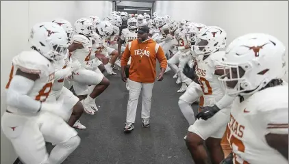  ?? (RICARDO B. BRAZZIELL/AUSTIN AMERICAN-STATESMAN VIA AP) ?? Texas director of football performanc­e Torre Becton warms up the team in the hallway before taking the field to compete against TCU in an NCAA college football game, Saturday, Nov. 11, 2023, in Fort Worth, Texas.