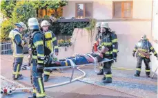  ??  ?? Konzentrie­rt und behutsam bringen die Feuerwehrk­ameraden die verletzten Personen in Sicherheit.