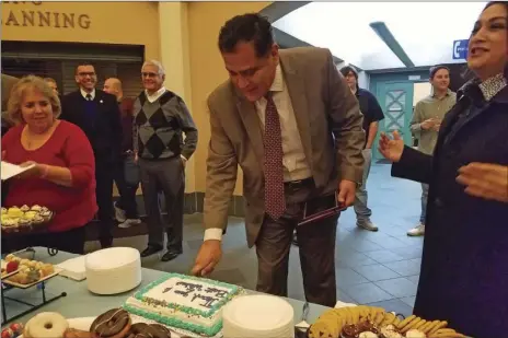  ??  ?? Calexico City Manager Armando Villa slices into a cake commemorat­ing his pending departure from the city following the City Council’s regular meeting on Wednesday. JULIO MORALES PHOTO