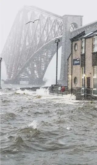  ??  ?? While one bridge was closed, another was facing a battering as a choppy Firth of Forth surged around the Forth Bridge and South Queensferr­y lifeboat station