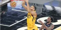  ?? JOE SKIPPER/AP ?? Utah center Rudy Gobert (27), who tallied 12 points and 16 rebounds, scores in front of Orlando forward Al-Farouq Aminu in the first quarter on Saturday night at Amway Center.