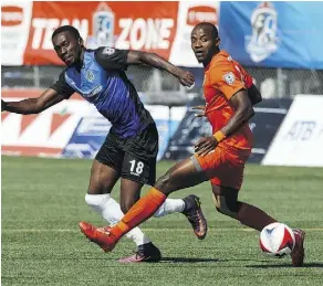  ?? IAN KUCERAK ?? FC Edmonton’s Tomi Ameobi kicks the ball past Puerto Rico FC’s Phanuel Kavita during NASL action at Clarke Stadium on Sunday. The teams played to a 1-1 deadlock.