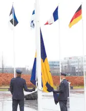  ?? ?? l Dos militares se preparan para izar la bandera de Suecia en una ceremonia para conmemorar la entrada del país en la OTAN.