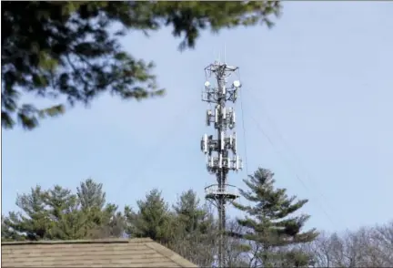  ?? ELISE AMENDOLA — THE ASSOCIATED PRESS ?? In this photo, a cell tower is seen through trees in North Andover, Mass. Insurance companies are using cellphone tower data to deny claims for stolen cars, burned homes and other mishaps, despite the informatio­n coming under question at criminal...