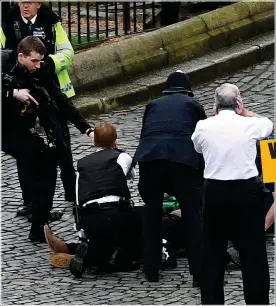  ??  ?? ATROCITY: Westminste­r killer Khalid Masood surrounded by armed police