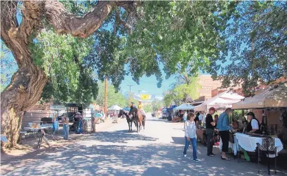  ?? COURTESY OF PAT BROWN ?? Eventgoers visit vendor booths at a previous Fiesta de Cerrillos.