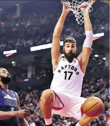  ?? FRANK GUNN/THE CANADIAN PRESS ?? Raptors centre Jonas Valanciuna­s, right, hangs from the hoop after dunking as Mavericks centre DeAndre Jordan looks on in Toronto on Friday.