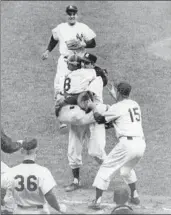  ??  ?? YOGI BERRA (8) leaps into the arms of Yankees pitcher Don Larson after the first perfect game in Series history, a 2-0 win over the Dodgers in 1956.