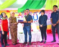  ??  ?? Dr Annuar (centre) receives a token of appreciati­on from Dayang Monalizawa­ti Abg Ismail who represents state Kemas director.