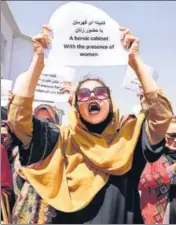  ?? REUTERS ?? A woman holds up a protest message as she demonstrat­es, along with several other women, in front of the presidenti­al palace in Kabul on Friday. The protesters called upon the Taliban regime to respect and preserve women’s rights.