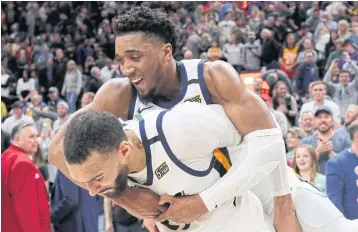  ??  ?? NBA stars Donovan Mitchell, top, and Rudy Gobert of the Jazz celebrate a win this season.