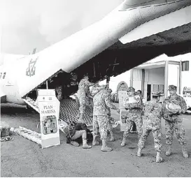  ??  ?? Marinos cargan los aviones que llevarán ayuda a los afectados.