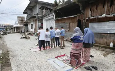  ?? PICTURE: AP ?? Volunteers pray in the middle of an abandoned street as they take part in a massive clean-up in Marawi city, southern Philippine­s, yesterday after being cleared of Islamic State group-linked militants.