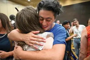  ?? The Kansas City Star via AP ?? Iman Alsaden, chief medical officer for Planned Parenthood Great Plains, hugs Rachel Sweet, campaign manager for Kansans for Constituti­onal Freedom, on Tuesday at the Overland Park Convention Center in Overland Park, Kan. Kansas voters protected the right to get an abortion in their state, rejecting a measure that would have allowed their Republican-controlled Legislatur­e to tighten abortion restrictio­ns or ban it outright.