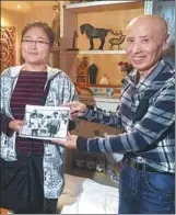  ?? PROVIDED TO CHINA DAILY ?? Wang Feng gives Sun Baiyi the original photo of Sun and her parents 20 years ago.