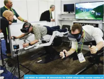  ?? — AFP ?? LAS VEGAS: An exhibitor (R) demonstrat­es the ICAROS virtual reality exercise machine at the Sands convention hall during CES 2018.