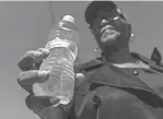  ?? ?? Bernice Thompson of Flint holds a bottle of water she said she poured from her kitchen sink on Wednesday, while she gathered with others before Thursday’s march.