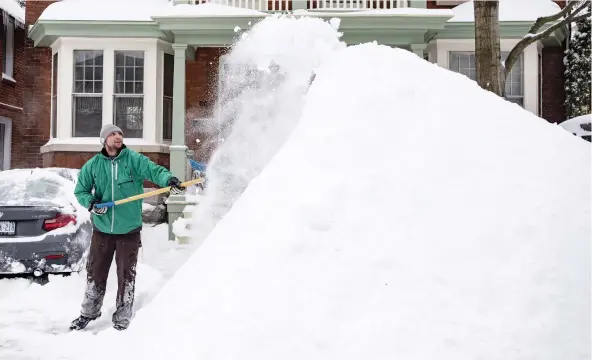  ?? JUSTIN TANG/THE CANADIAN PRESS ?? James Liston throws more snow onto a massive pile as he helps clear a neighbour’s driveway in the Glebe on Wednesday.