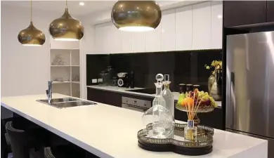  ?? Photo: John Fotiadis ?? A combinatio­n of objects of different heights on a tray make up this vignette in the Santorini 26 by Coral Homes. Trays are a great way to contain a display and unit objects within a larger space such as a kitchen benchtop.