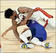  ?? AP-Kevin C. Cox ?? Denver Nuggets’ Monte Morris, bottom, and Miami Heat’s Jimmy Butler scramble for the ball during a game in Lake Buena Vista, Fla. on Saturday.