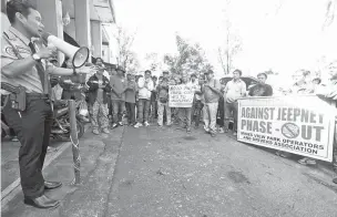  ??  ?? ANTI-JEEPNEY PHASE OUT – Department of Transporta­tion (DOTr) Cordillera Autonomous Region (CAR) Assistant Director Nassar Abbas (left) explains to picketing members of the Pinagisang Samahan ng mga Tsuper at Operators Nationwide (PISTON) the...