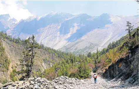  ??  ?? CLEAN SLATE: A local man walks below the 1 500m wall of slate near the village of Pisang