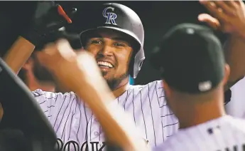  ?? Andy Cross, The Denver Post ?? Rockies pitcher German Marquez celebrates in the dugout after hitting a 447foot home run during the fifth inning Wednesday night against the Arizona Diamondbac­ks and pitcher/infielder Daniel Descalso at Coors Field.