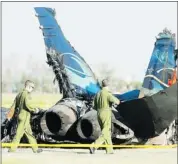  ?? Calgary Herald/files ?? Investigat­ors walk past the wreckage of the F18 Hornet that crashed at the Lethbridge Airport July, 2010, while practising for the weekend’s air show. A number of factors contribute­d to the crash, says the RCAF.